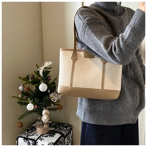 Chic cream and khaki woven leather tote bag shown on shoulder for daily commute style