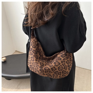 Detail view of large leopard print hobo bag with wide shoulder strap on model