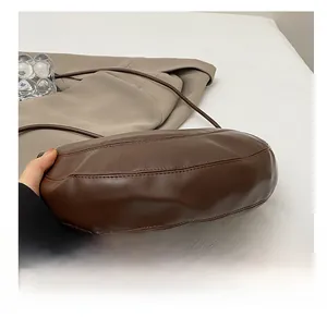 Gros plan détaillé de la base résistante à l'usure du sac besace en cuir marron