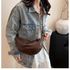 Vue latérale du sac demi-lune marron foncé avec détail de nœud porté par un mannequin