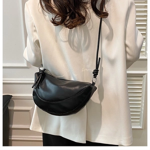 Détail du sac bandoulière demi-lune noir avec boucles argentées et bandoulière nouée