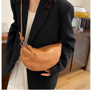 Détail du sac bandoulière demi-lune en cuir marron avec sangle nouée et fermeture éclair