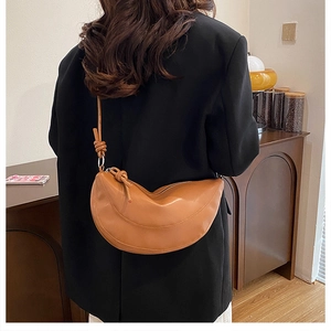 Sac demi-lune en cuir marron avec détail de nœud, porté par un mannequin en vue arrière