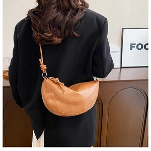 Détail du sac demi-lune en cuir caramel avec une bandoulière à nœud réglable