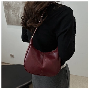 Détail du sac hobo bordeaux en similicuir avec bandoulière en chaîne métallique tressée