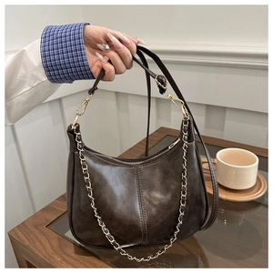 Détail du sac croissant rétro en similicuir marron avec chaîne dorée et fine bandoulière