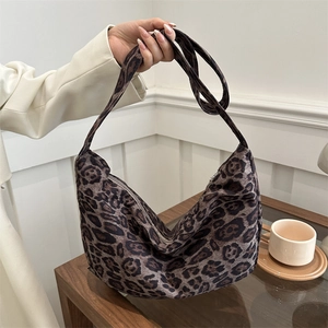 Minimalist leopard print half-moon hobo bag with wide shoulder strap and metal zipper