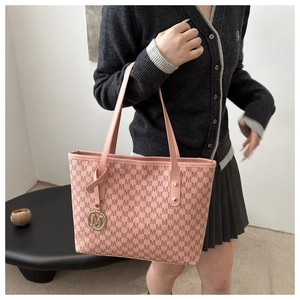 Detail of pink monogram tote bag with gold-tone M charm and adjustable crossbody strap