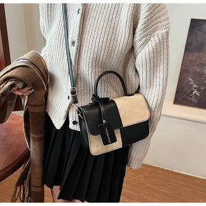 Detail of a vintage contrast patchwork crossbody bag with fashion tag and leather texture