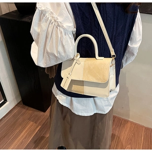 Detail of a beige patchwork crossbody bag with smooth leather and suede textures