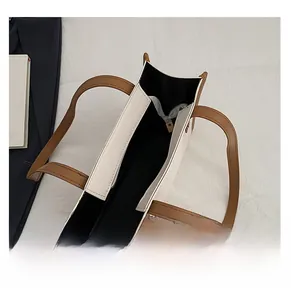 Interior detail of two-tone tote bag featuring black fabric lining and zippered pocket