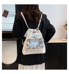 Detail of white canvas backpack with lace edges and clear mesh pocket for accessories