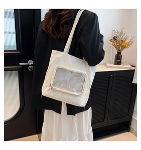 White nylon tote bag with transparent mesh zipper pocket and minimalist shoulder straps