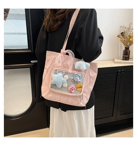 Detail of pink nylon ita bag with transparent window, strawberry bear and star charms