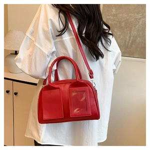 Détail du sac Boston rouge avec fente transparente pour photo et boucles en argent