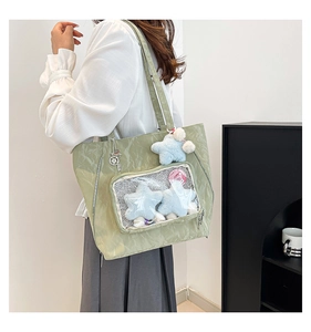 Side view of light green tote bag with pleated texture and transparent DIY window