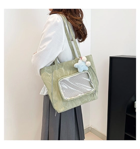 Light green nylon tote bag with clear mesh pocket and blue star plush charm detail