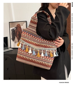 Dettaglio ravvicinato di una borsa etnica in tela intrecciata con nappe colorate decorative