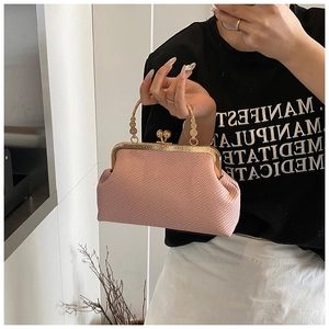 Détail du sac tissé rose avec poignée en métal doré et fermoir à boule de style rétro