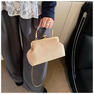 Détail du sac beige tissé avec cadre doré et fermeture vintage à fermoir baiser