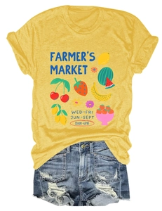 Detail of ginger yellow t-shirt with fruit market print and distressed denim shorts