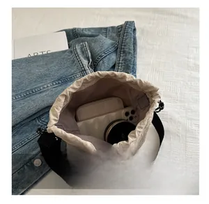 Vista interna della borsa a secchiello beige con coulisse e spazio per cellulare