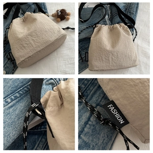 Dettaglio borsa a secchiello plissettata beige con coulisse ed etichetta in tessuto Fashion