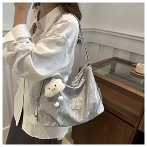 Close-up of metallic silver large tote bag with soft pleated fabric and plush cloud charm