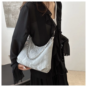 Detail of grey marble pattern tote bag with silver chain strap on model shoulder