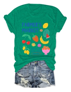 Detail of green T-shirt with Farmer's Market fruit print and frayed denim shorts
