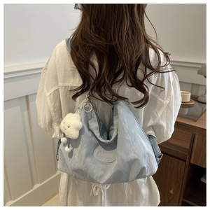 Close-up of light blue large capacity backpack with cloud pendant on female model