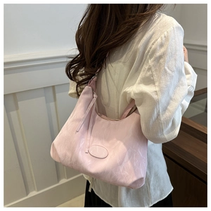 Detail of soft pale pink hobo bag with unique wrinkled texture and elegant shoulder fit