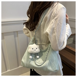 Detail of light green shoulder bag with pleated texture and cute white cloud pendant