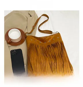 Vista dettagliata della borsa bohémien marrone con frange e occhielli metallici argentati