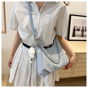 Detail of light blue pleated hobo bag with metal chain and plush cloud charm