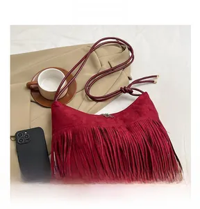 Gros plan détaillé du sac hobo bordeaux avec de longues franges en daim et nœud