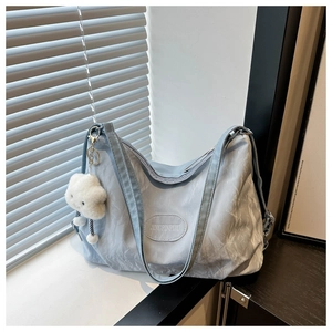 Detail of light blue pleated large capacity shoulder bag with cloud charm accessory