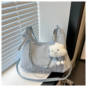 Dettaglio borsa in nylon azzurro con catena argento e ciondolo a nuvola bianca carino