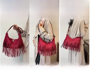Sac demi-lune en daim rouge à franges porté en bandoulière et à l'épaule