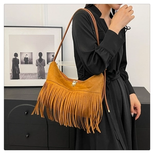 Détail d'un sac à bandoulière en daim marron avec de longues franges bohèmes