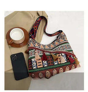 Dettaglio della borsa etnica boho con motivi tribali colorati e nappine a frangia