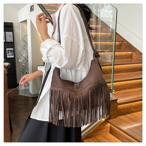 Détail du sac hobo en faux daim marron foncé avec de longues franges et double fermeture