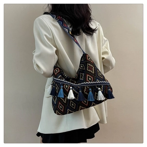 Close-up of ethnic tote bag featuring bohemian patterns and colorful fringe tassels