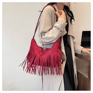 Détail du sac hobo bordeaux en faux daim avec des franges denses et une bandoulière nouée