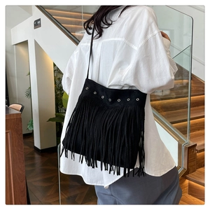 Borsa a tracolla boho nera con frange e occhielli argento indossata da una modella