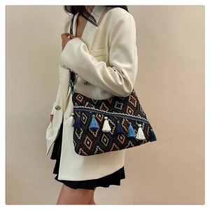 Detailed shot of ethnic woven tote featuring geometric patterns and multi-color tassels