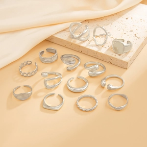 Detail of 14-piece silver geometric rings set on stone and satin background