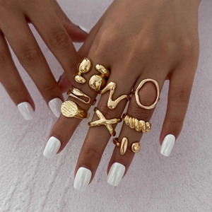 Minimalist gold liquid metal ring set with irregular geometric designs on female model