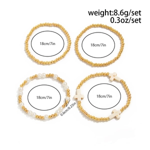 Macro detail of 4-piece gold bead and pearl bracelet set with cross charms and dimensions
