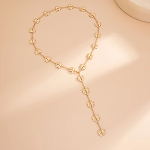Dettaglio della collana a farfalla dorata a forma di Y con elegante pendente nappa
